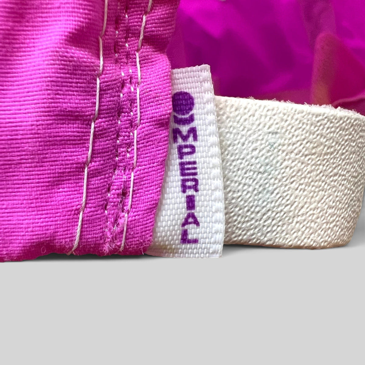 Raree Finds vintage Imperial hat interior tag showing brand logo on neon pink nylon fabric with white stitching