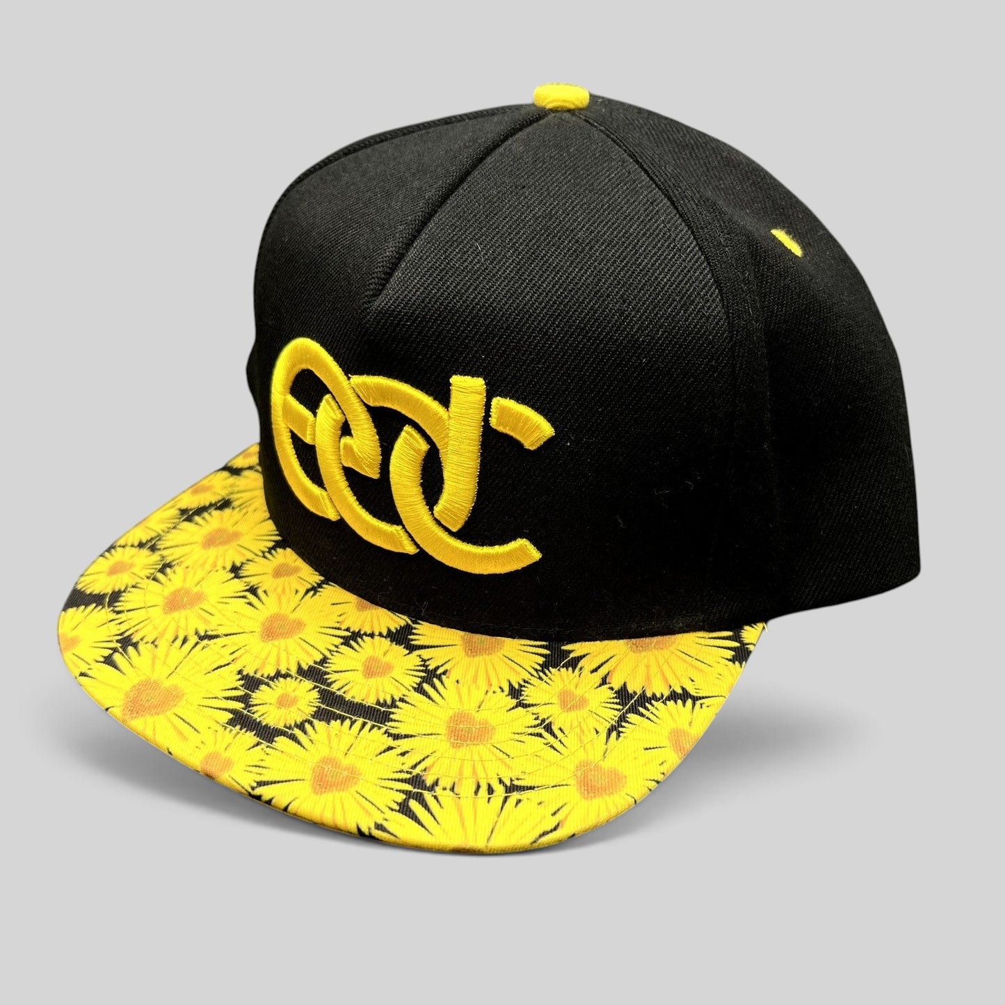 Raree Finds Insomniac EDC snapback hat with a black crown, yellow embroidered logo, and sunflower print flat brim.