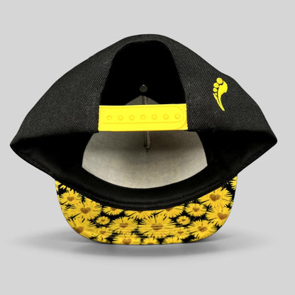 Raree Finds Insomniac EDC snapback hat featuring a black crown, yellow snap closure, and sunflower-print flat brim.