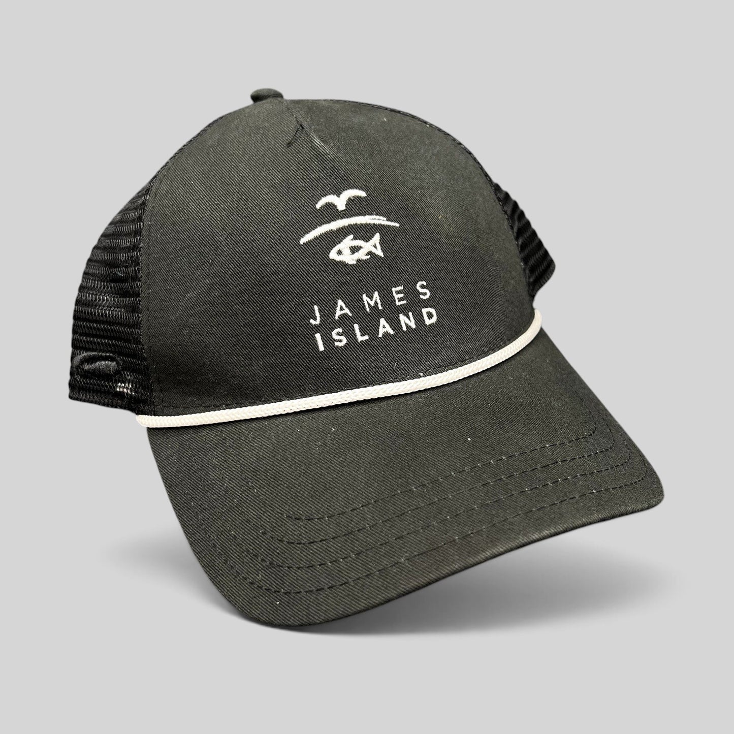 Raree Finds black trucker hat with white James Island coastal logo embroidery, mesh back, and rope detail on the brim.