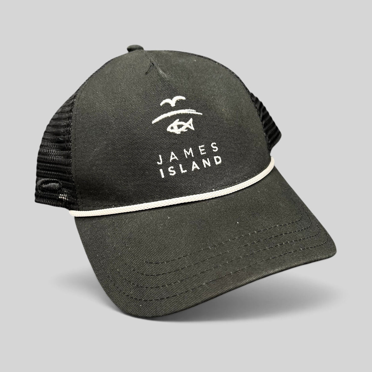 Raree Finds black trucker hat with white James Island coastal logo embroidery, mesh back, and rope detail on the brim.