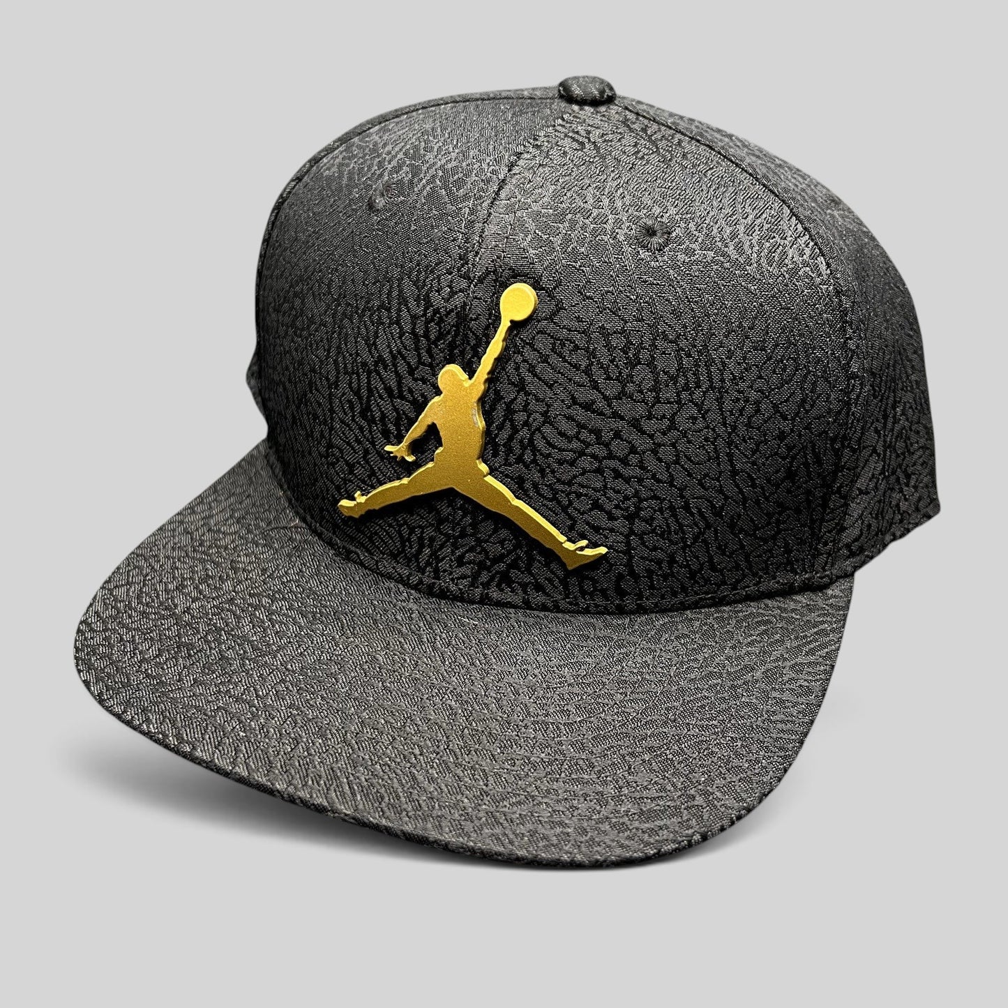 Raree Finds youth Jordan snapback hat in black with an elephant print texture and a metallic gold Jumpman logo.
