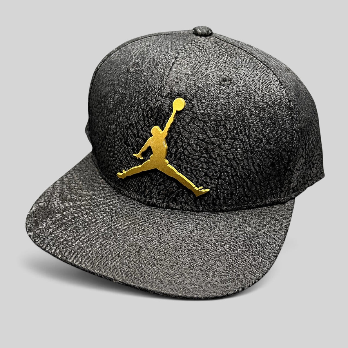 Raree Finds youth Jordan snapback hat in black with an elephant print texture and a metallic gold Jumpman logo.