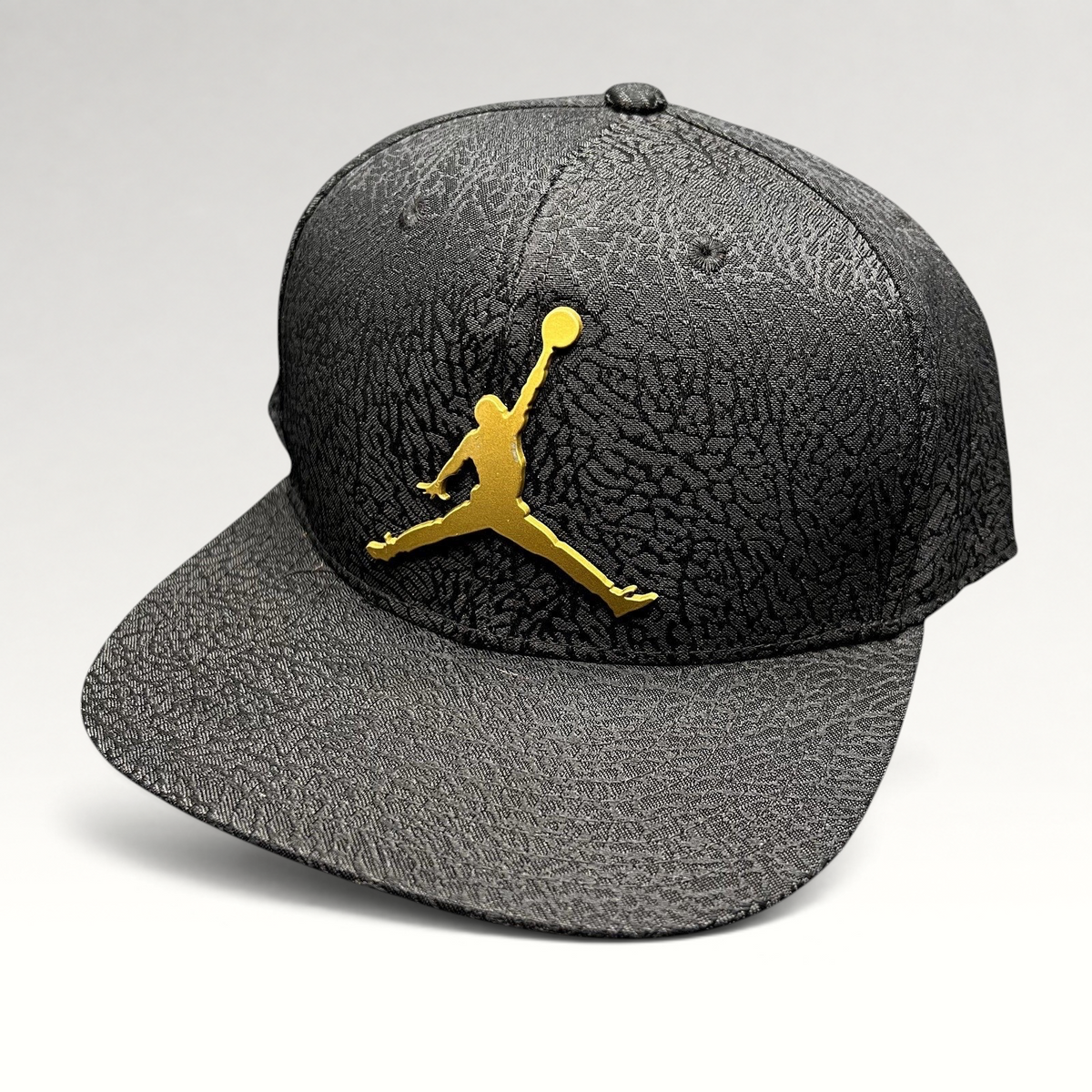 Raree Finds youth Jordan snapback hat in black with an elephant print texture and a metallic gold Jumpman logo.