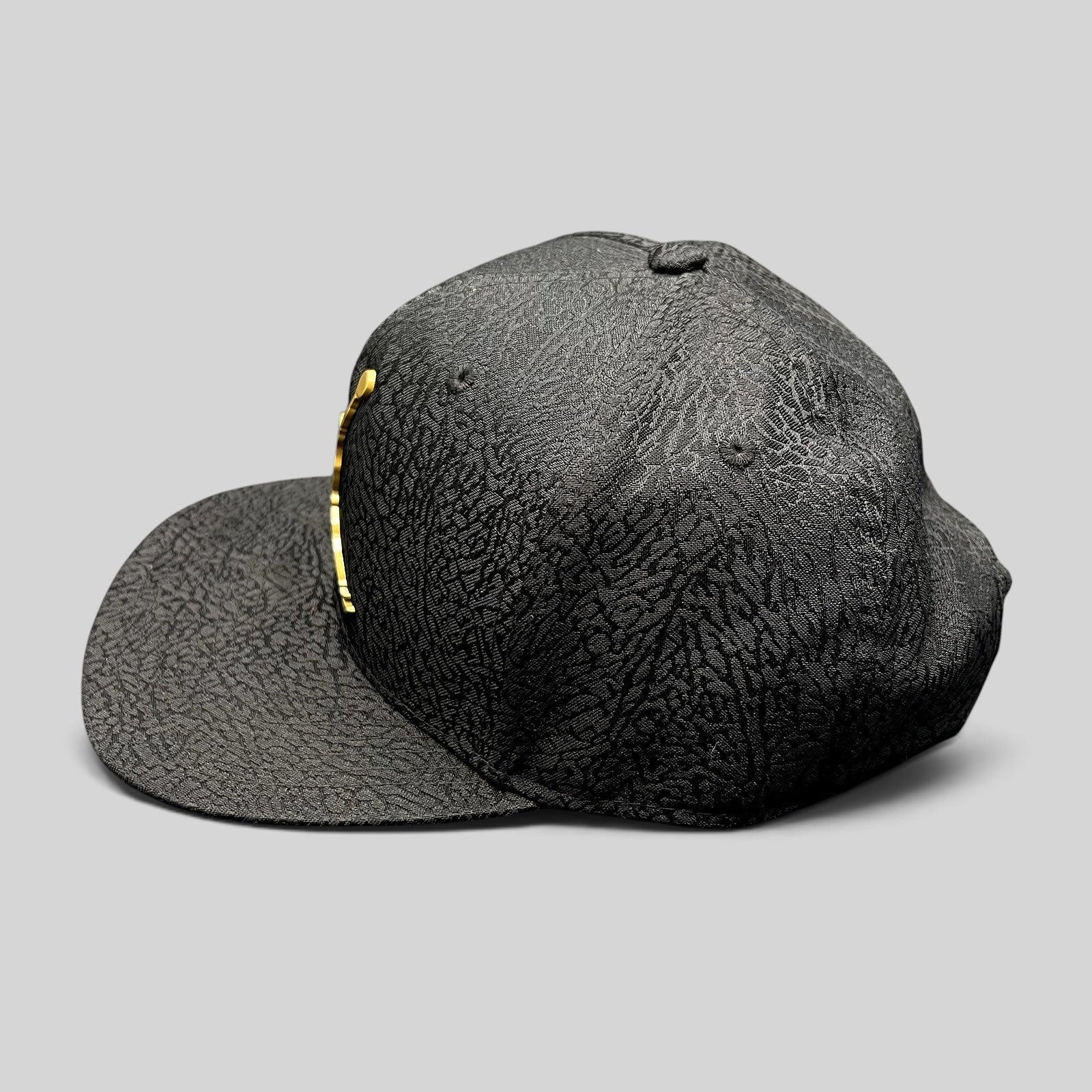 Raree Finds youth Jordan snapback hat in black with textured elephant print and a metallic gold Jumpman logo