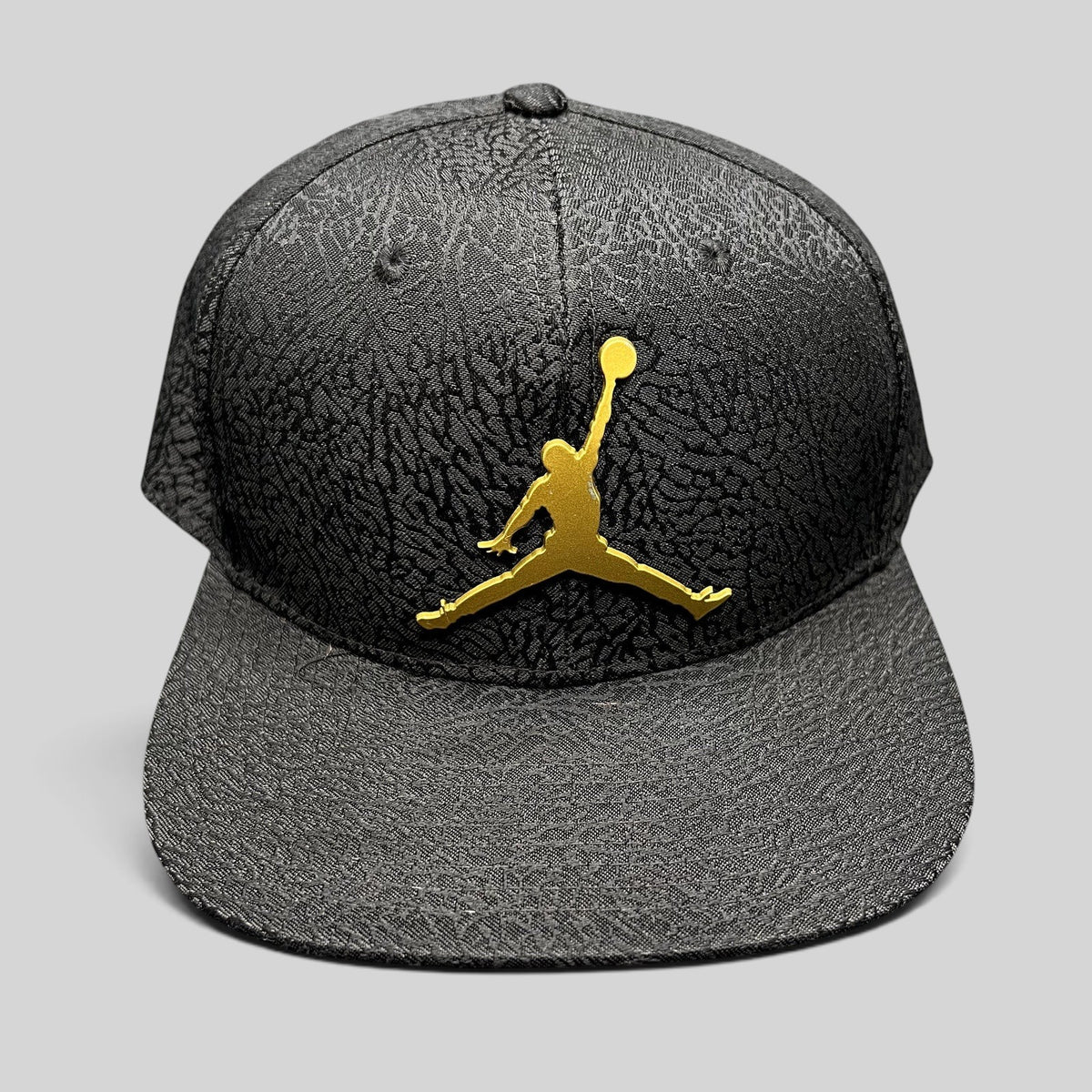 Raree Finds youth Jordan snapback hat in black with an elephant print texture and a metallic gold Jumpman logo.