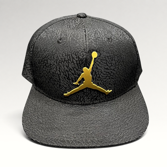 Raree Finds youth Jordan snapback hat in black with an elephant print texture and a metallic gold Jumpman logo.