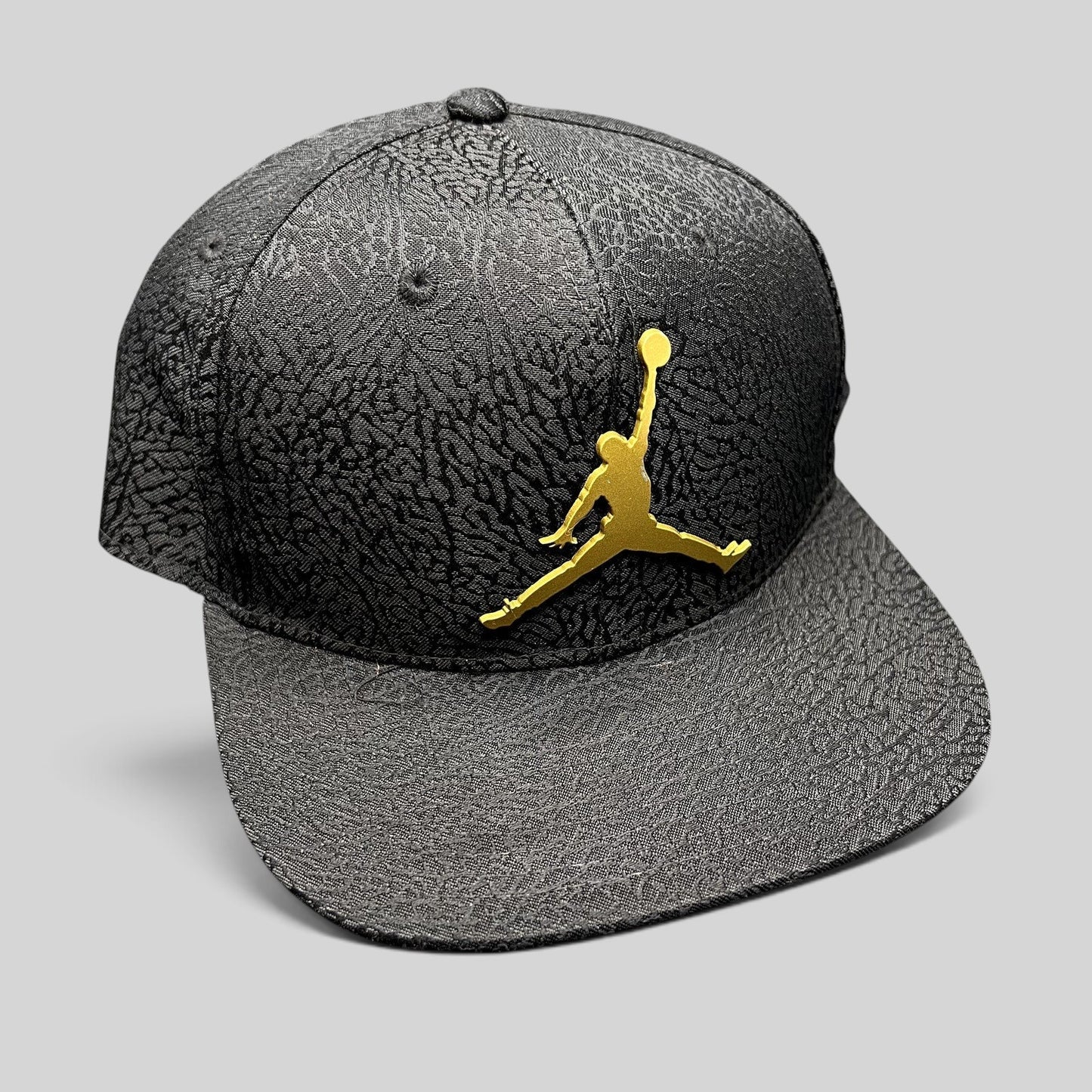 Raree Finds youth Jordan snapback hat in black with elephant print texture and a metallic gold Jumpman logo.
