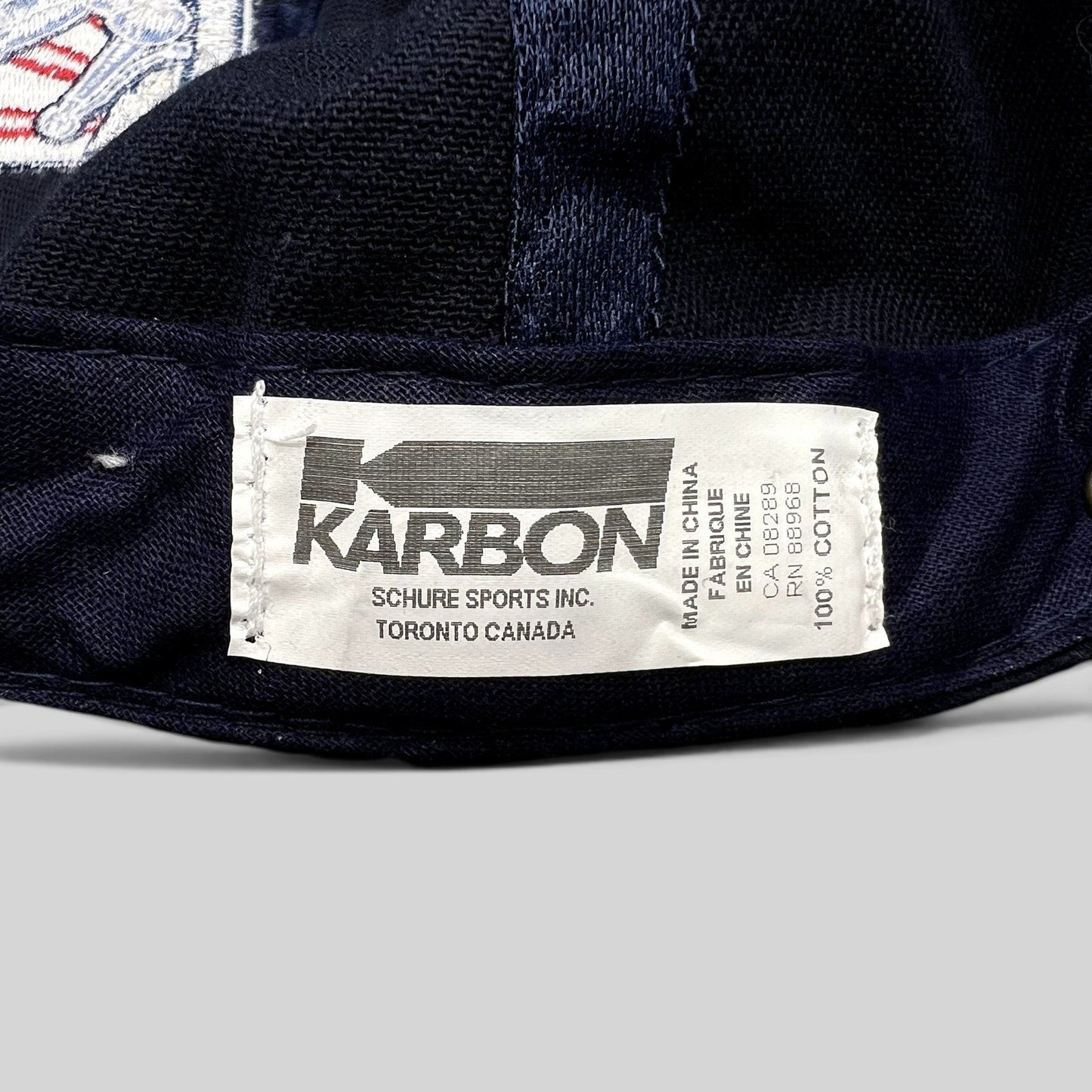Raree Finds navy blue cotton hat interior label featuring Karbon Canada branding and manufacturing details