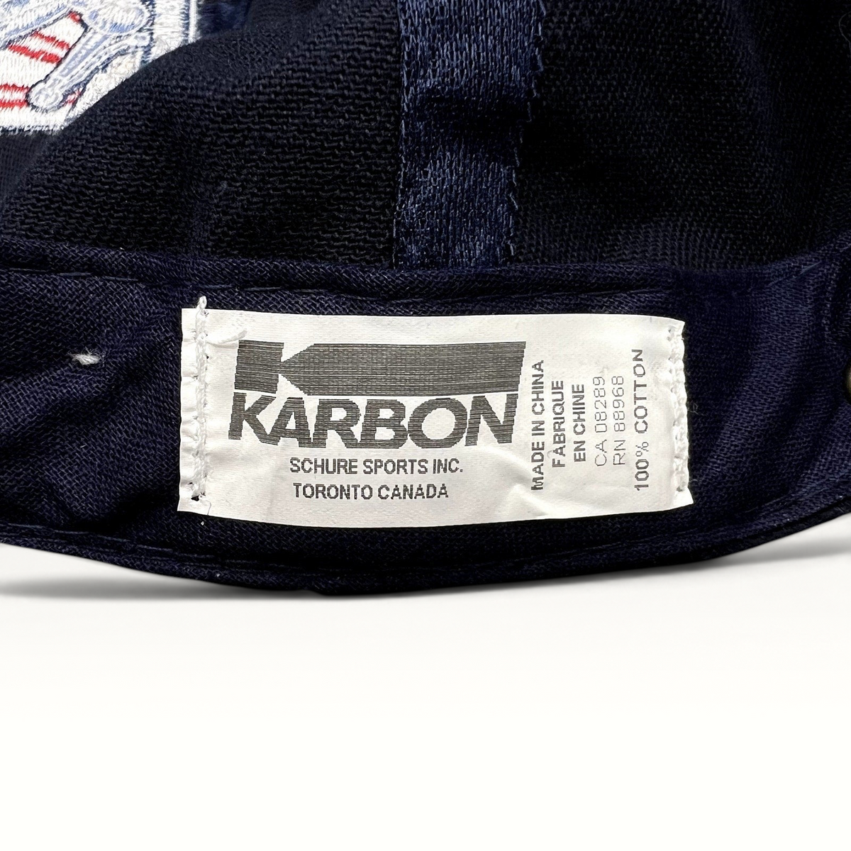 Raree Finds navy blue cotton hat interior label featuring Karbon Canada branding and manufacturing details