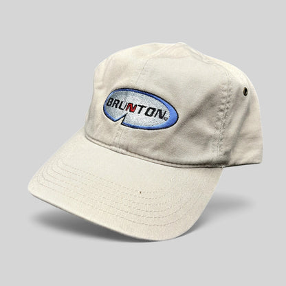Raree Finds vintage khaki cotton Richardson strapback hat featuring an embroidered Brunton logo and navy underbrim.