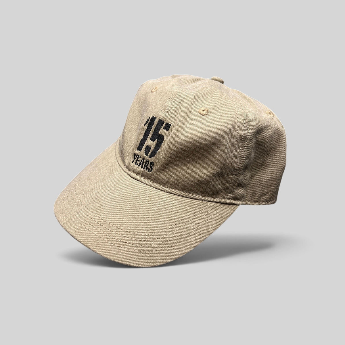 Raree Finds khaki garment-washed cotton dad hat with embroidered 15 Years festival graphic and curved brim