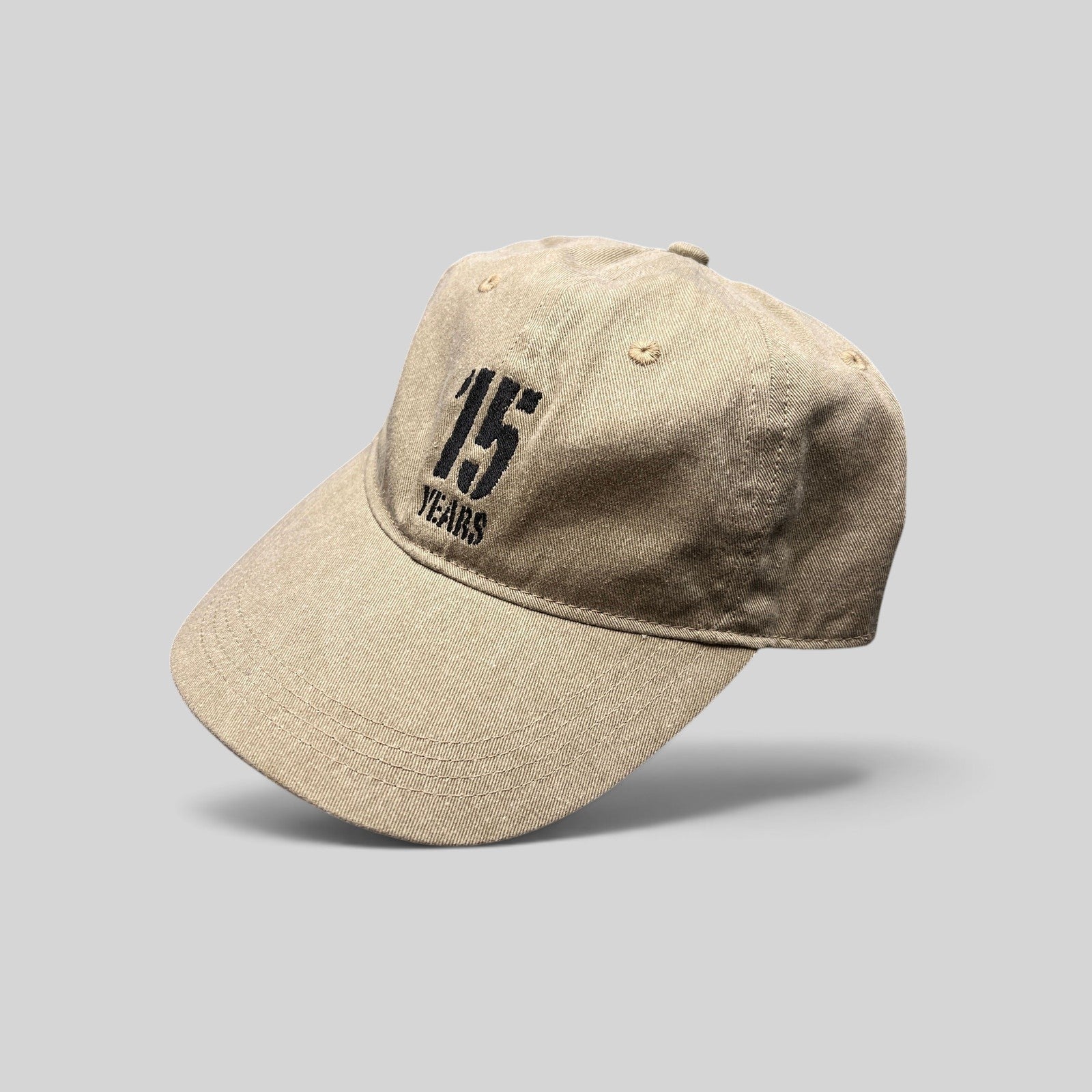 Raree Finds khaki garment-washed cotton dad hat with embroidered 15 Years festival graphic and curved brim