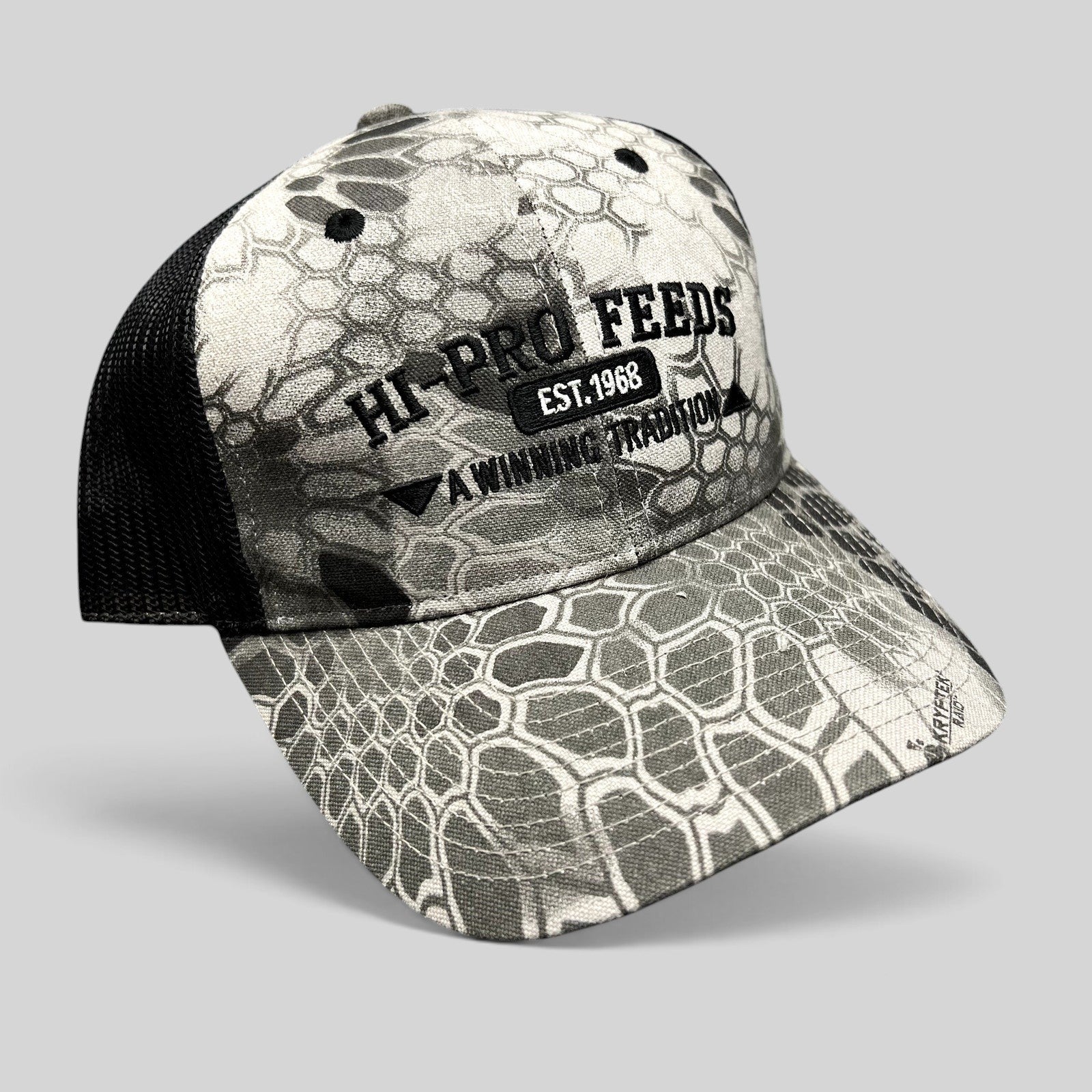 Raree Finds Hi-Pro Feeds trucker hat in gray and black Kryptek Raid camo with black mesh back and embroidered logo.