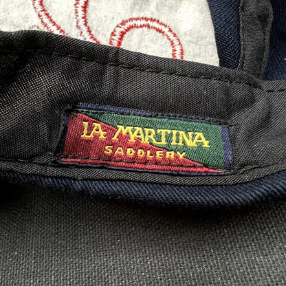 Raree Finds vintage La Martina Saddlery interior woven brand label in red, green, and gold on navy blue cotton fabric.