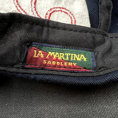 Raree Finds vintage La Martina Saddlery interior woven brand label in red, green, and gold on navy blue cotton fabric.