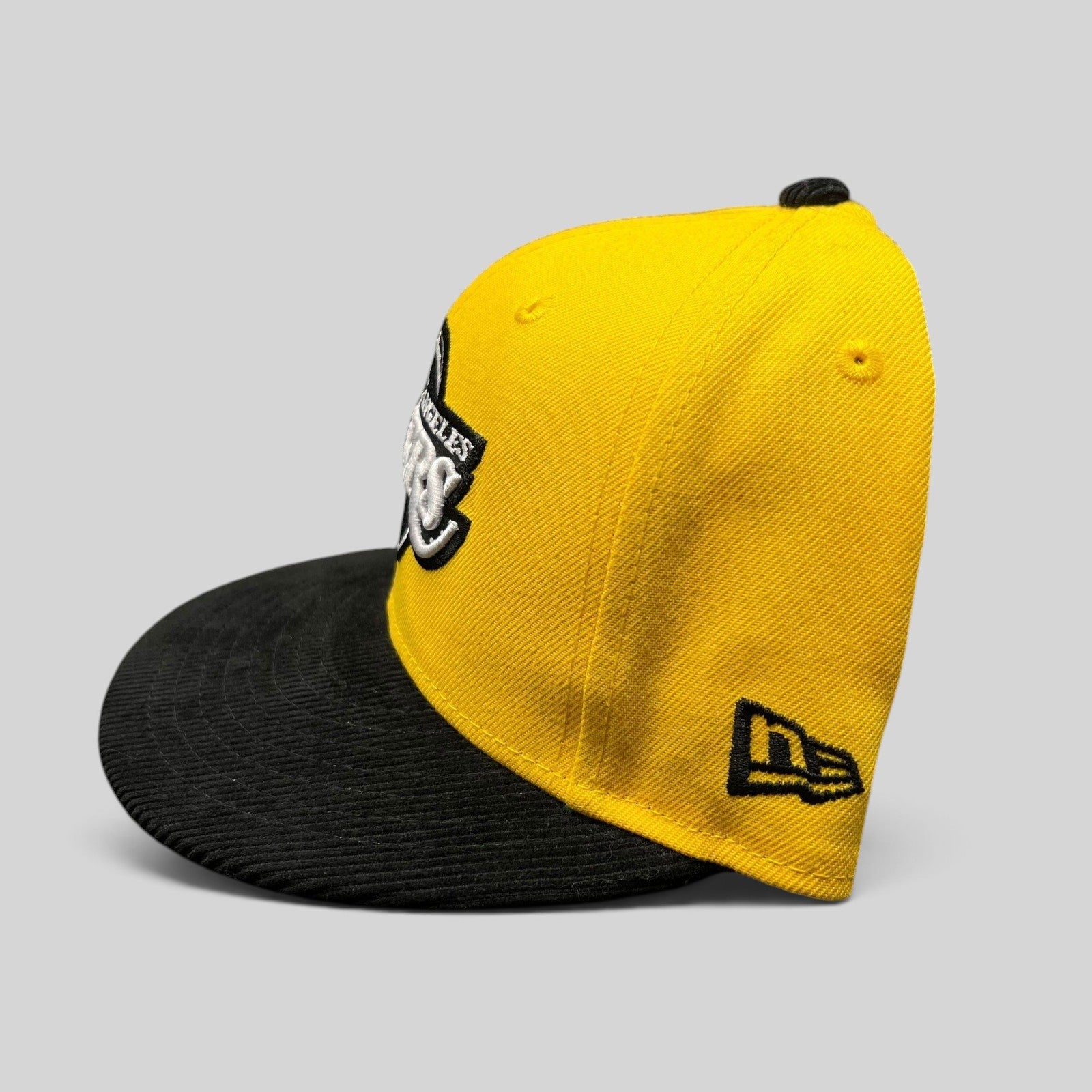 Raree Finds Los Angeles Lakers 9FIFTY snapback hat with a gold crown and black corduroy brim, side profile view.
