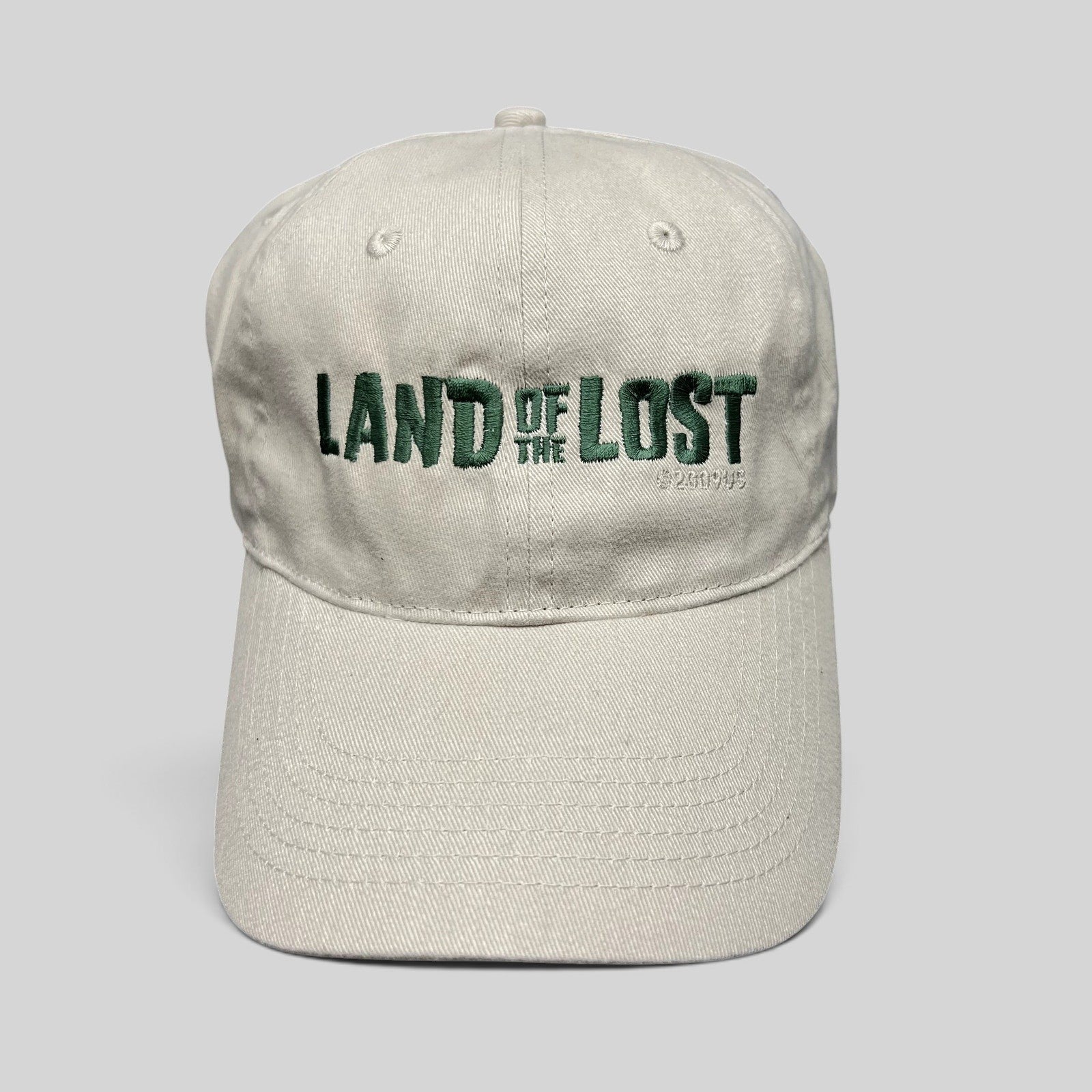 Raree Finds off-white cotton strapback hat with green Land of the Lost movie embroidery and curved brim