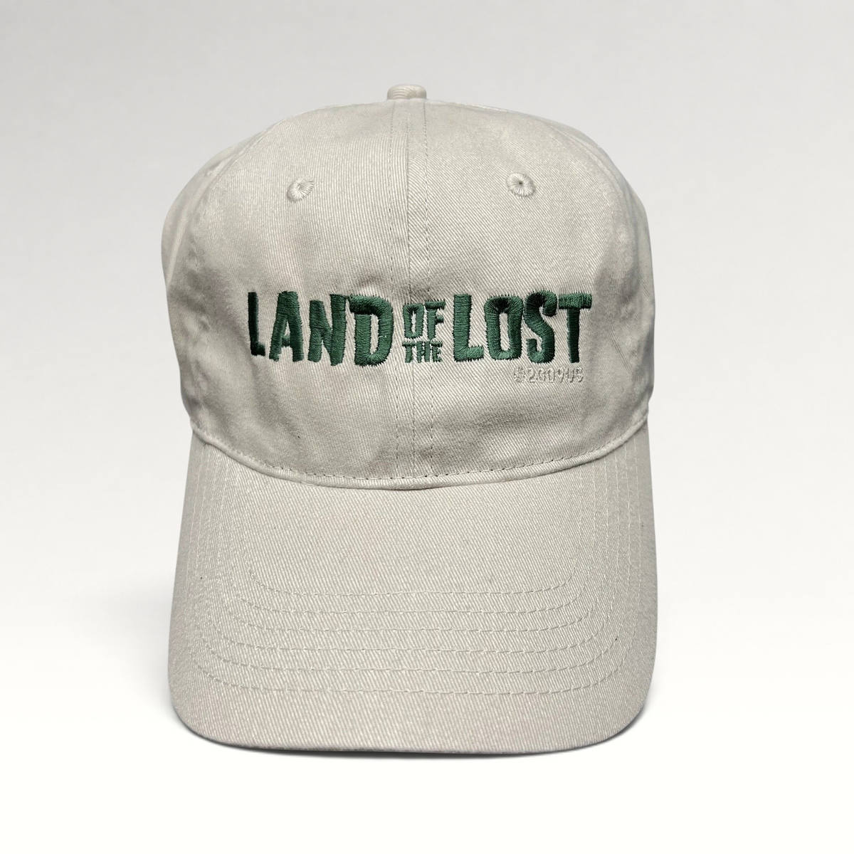 Raree Finds off-white cotton strapback hat with green Land of the Lost movie embroidery and curved brim