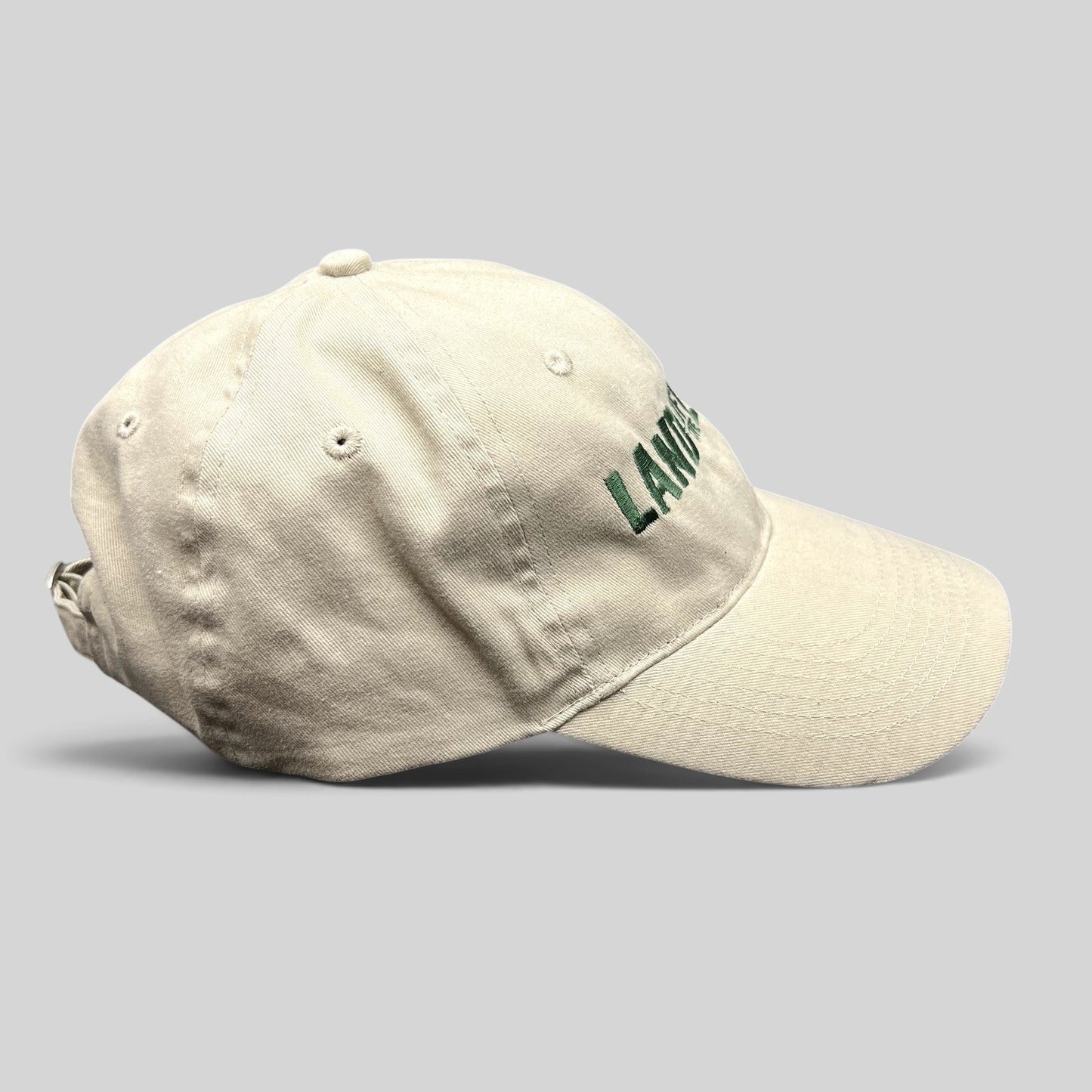 Raree Finds off-white cotton strapback hat with green Land of the Lost movie embroidery and curved brim