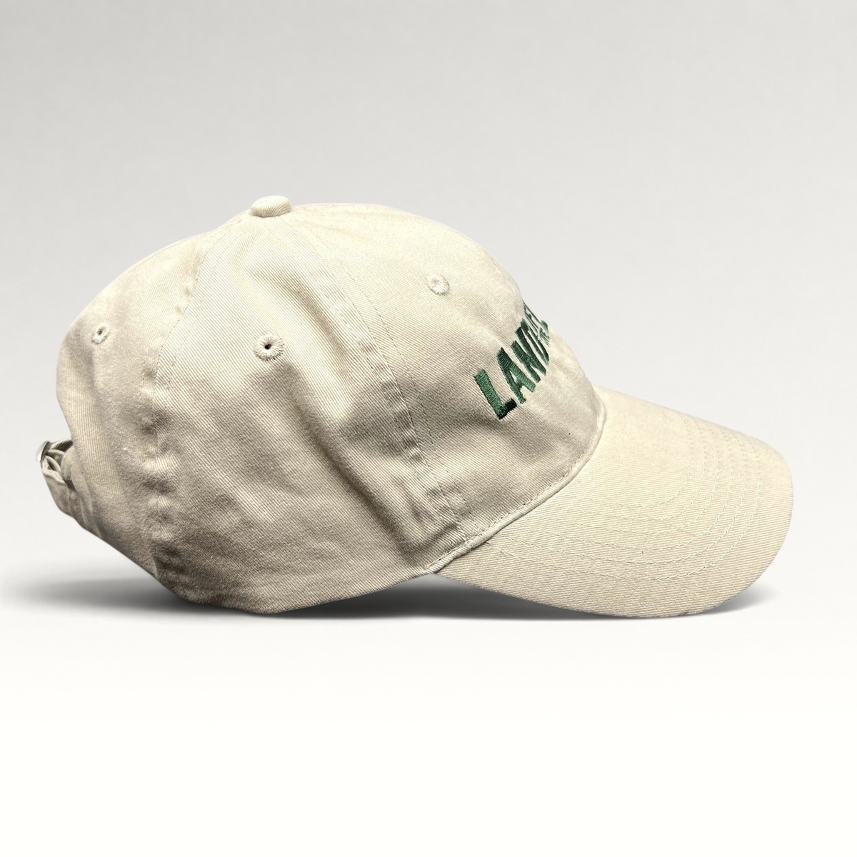 Raree Finds off-white cotton strapback hat with green Land of the Lost movie embroidery and curved brim