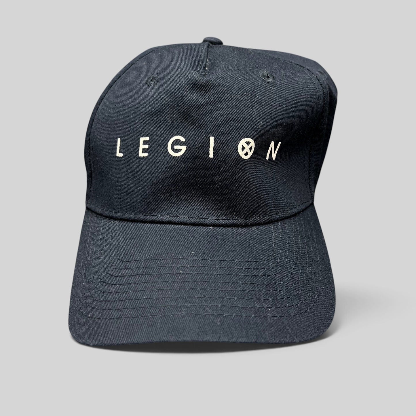 Raree Finds black Legion Marvel TV series strapback hat with white logo embroidery and adjustable rear closure.