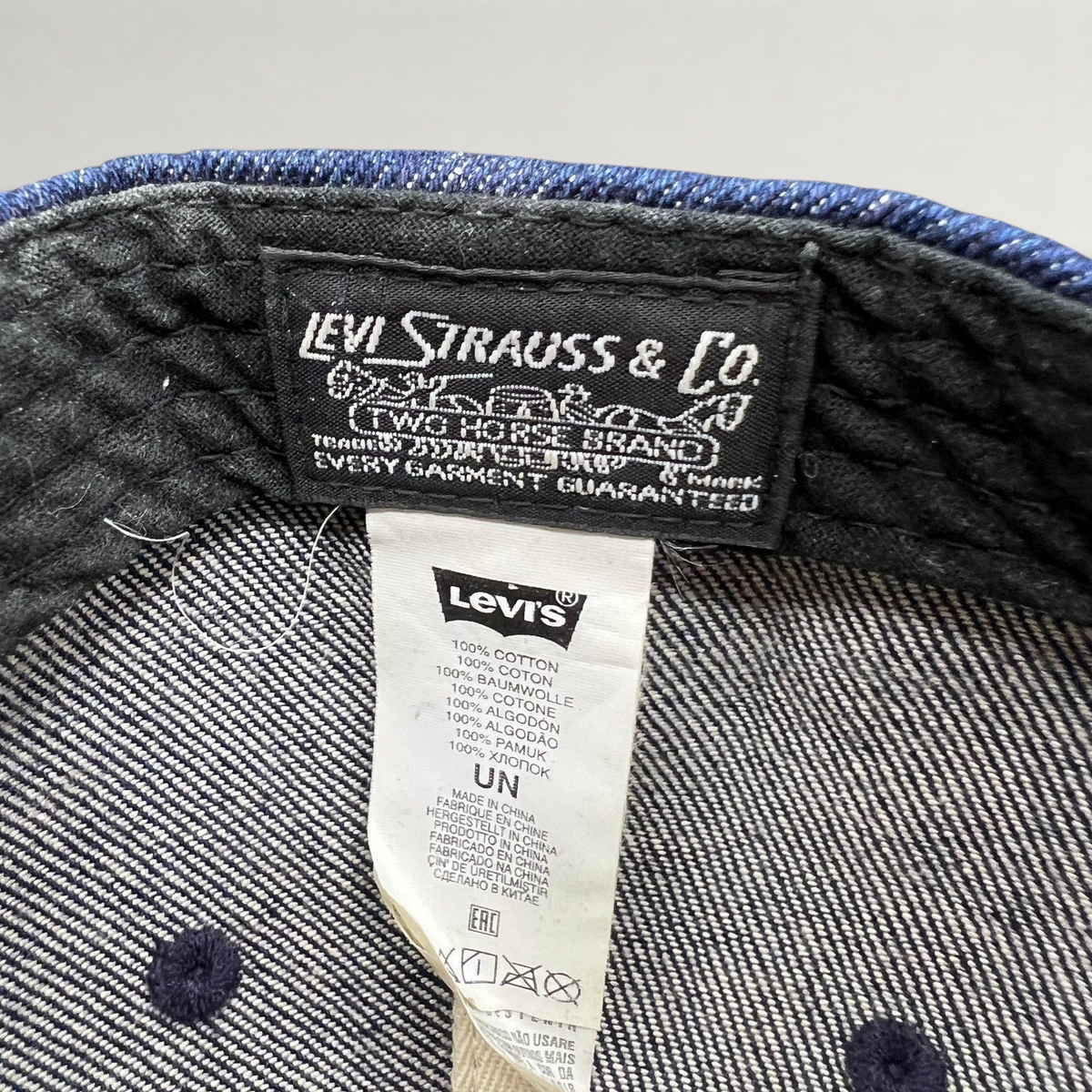 Raree Finds Levi Strauss & Co denim cap interior showing woven brand label and 100% cotton care tag