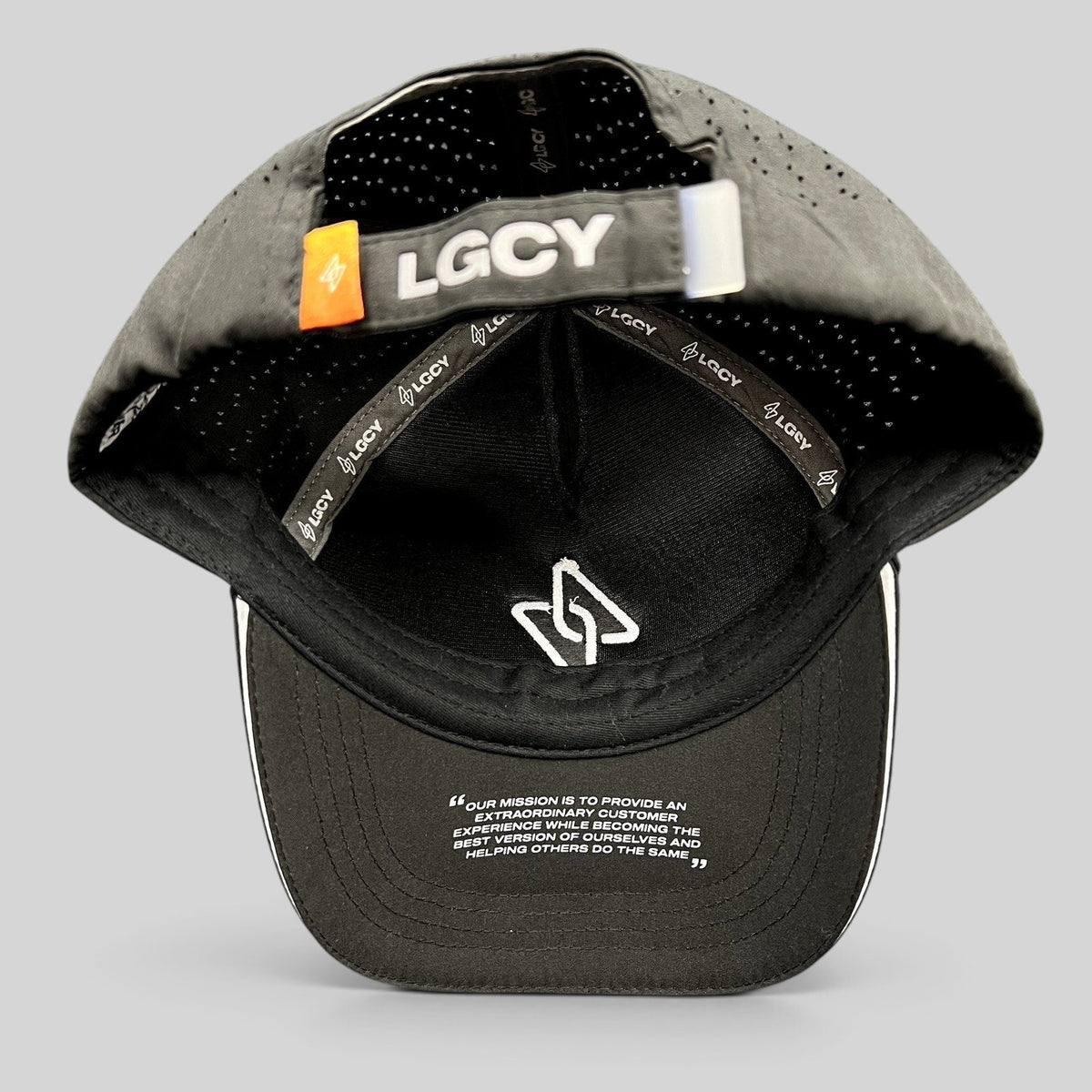 Raree Finds LGCY black performance strapback hat showing interior branded tape, perforated panels, and underbrim quote.