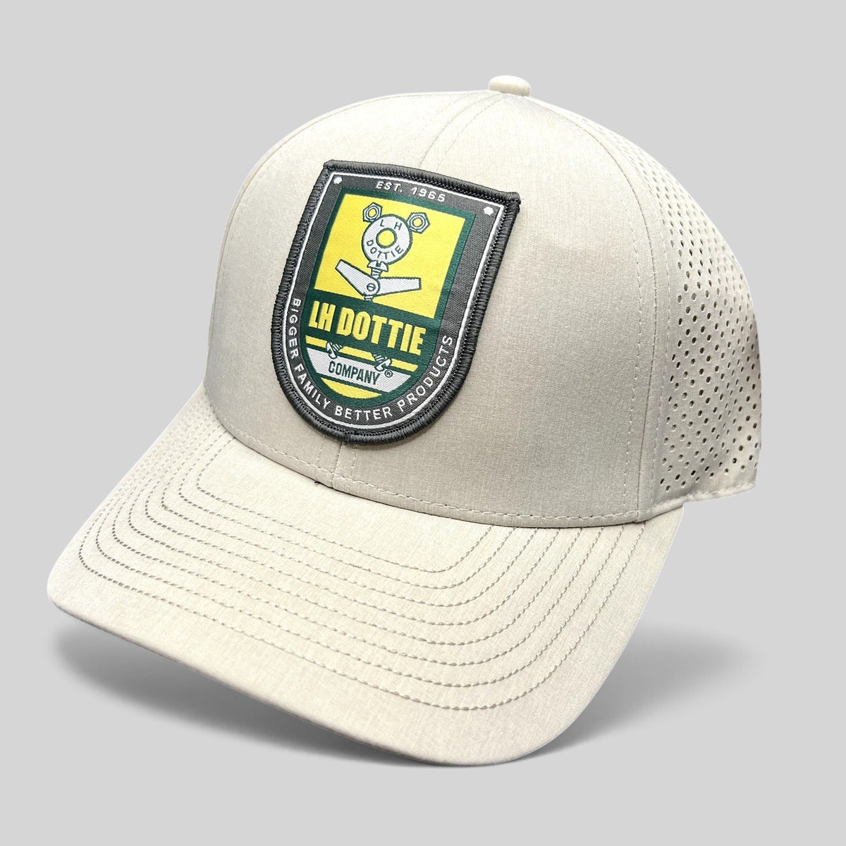Raree Finds LH Dottie Company tan snapback hat with embroidered shield logo, perforated panels, and curved brim.