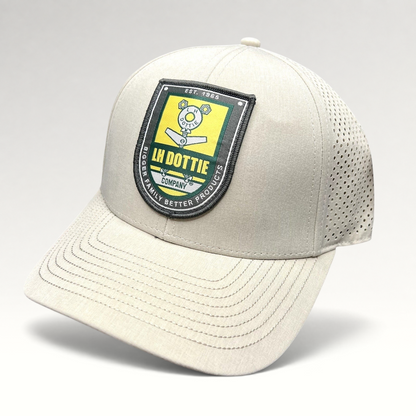Raree Finds LH Dottie Company tan snapback hat with embroidered shield logo, perforated panels, and curved brim.