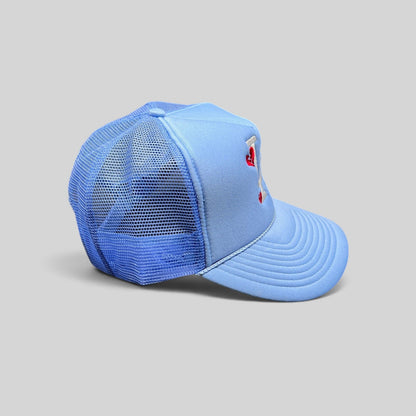 Raree Finds light-blue Y2K trucker hat with white LA logo and red broken-heart embroidery on a foam front mesh cap.