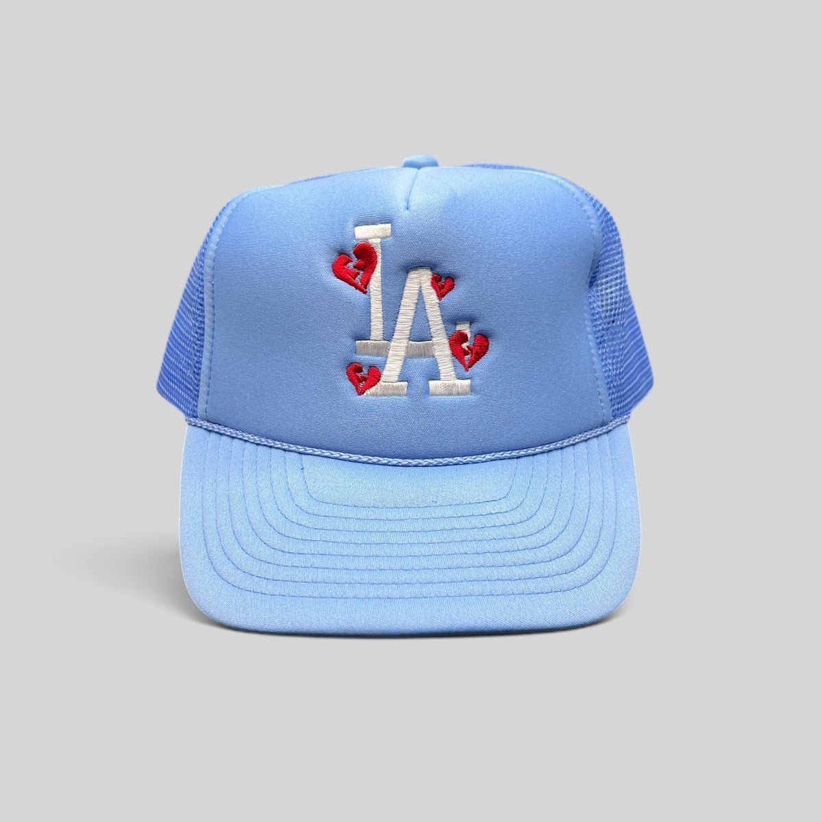 Raree Finds light-blue Sun Cap trucker hat with white LA logo and red broken-heart embroidery on a foam front.
