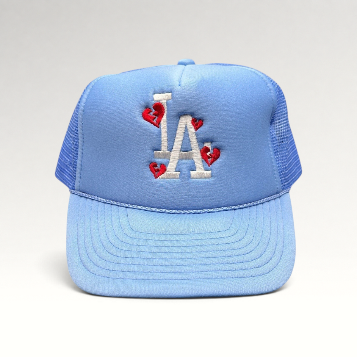 Raree Finds light-blue Sun Cap trucker hat with white LA logo and red broken-heart embroidery on a foam front.