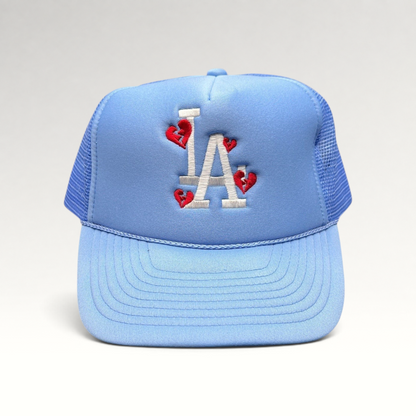 Raree Finds light-blue Sun Cap trucker hat with white LA logo and red broken-heart embroidery on a foam front.