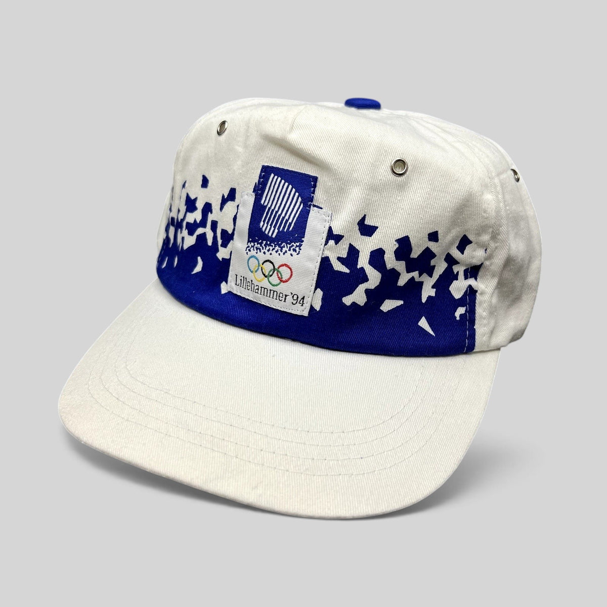 Raree Finds vintage 1994 Lillehammer Winter Olympics hat with white crown, blue brim, and Olympic emblem patch.