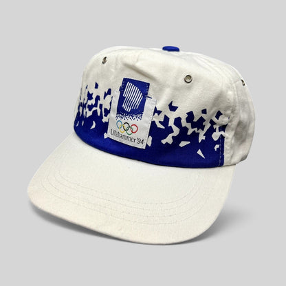 Raree Finds vintage 1994 Lillehammer Winter Olympics hat with white crown, blue brim, and Olympic emblem patch.