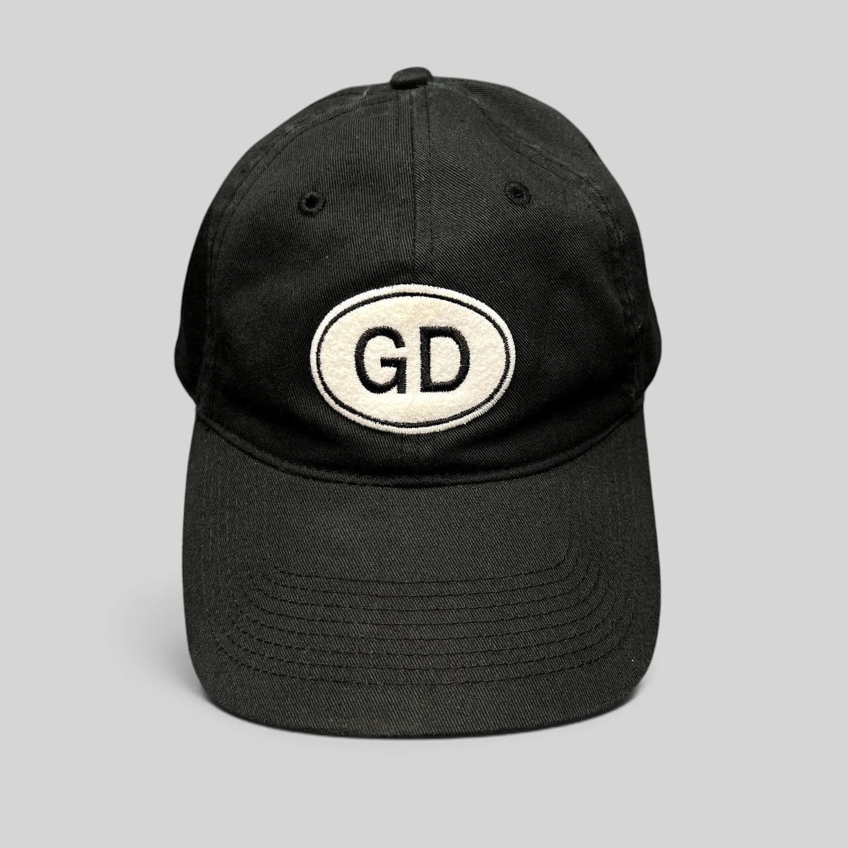 Raree Finds black cotton strapback hat by Liquid Blue featuring a white oval GD logo patch on the front