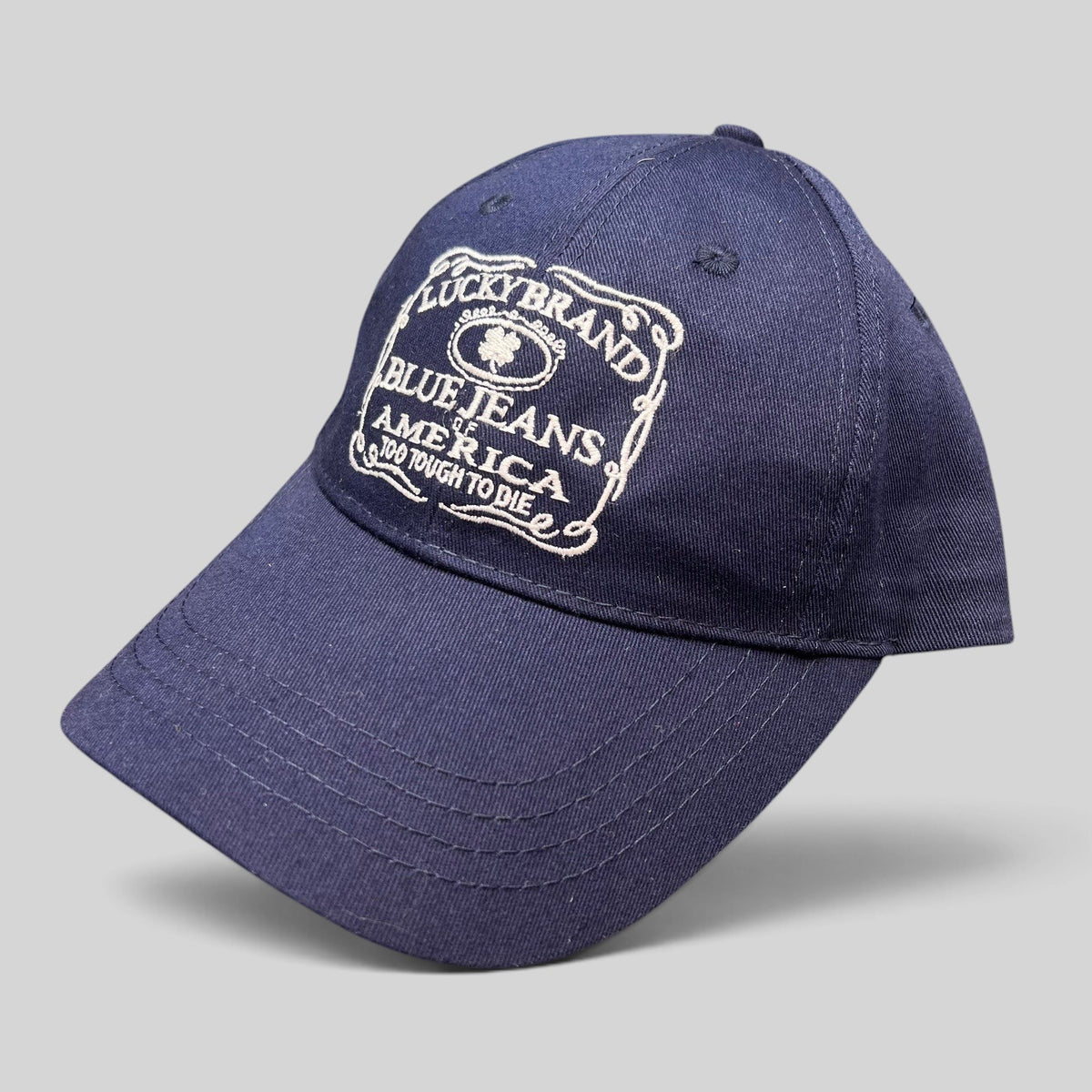 Raree Finds navy cotton twill Lucky Brand snapback hat with white vintage logo embroidery and curved brim.
