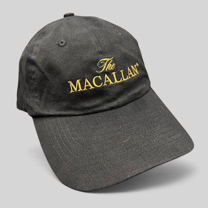 Raree Finds black cotton baseball cap featuring The Macallan logo embroidered in gold thread on the front panel.