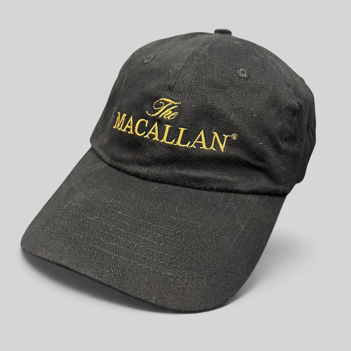 Raree Finds black strapback hat with gold embroidered The Macallan logo on the front panel