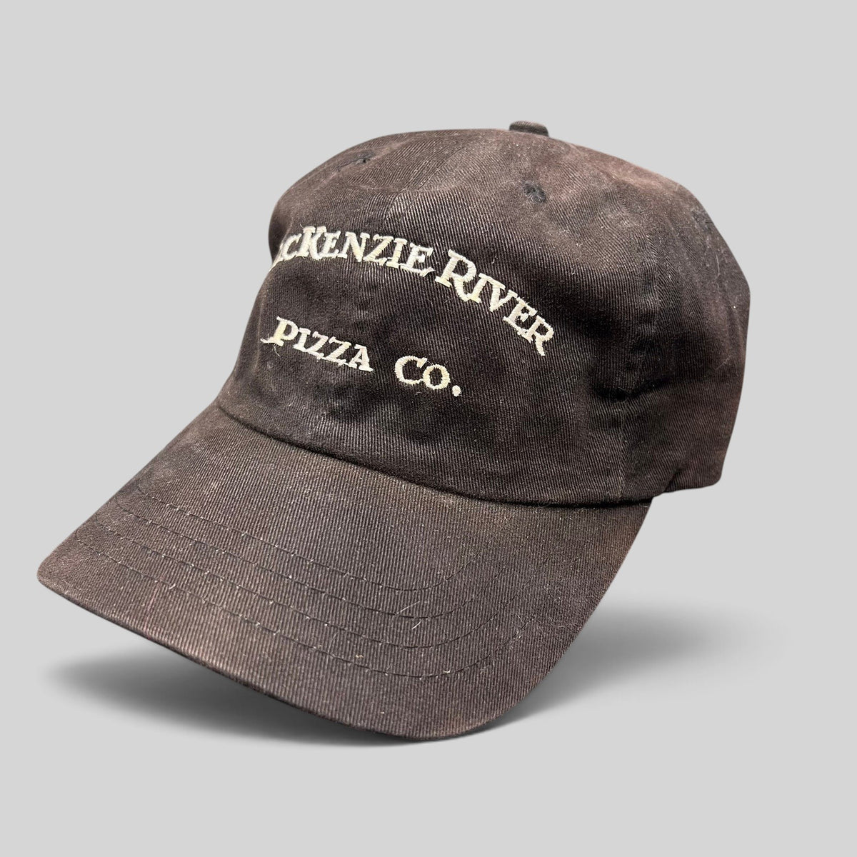 Raree Finds vintage dark brown Mackenzie River Pizza Co. strapback hat with white embroidered lettering.
