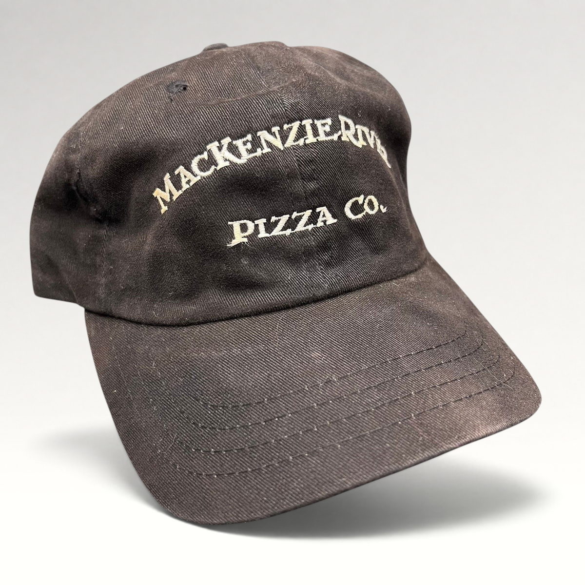 Raree Finds vintage dark brown Mackenzie River Pizza Co. strapback cap with white embroidered lettering.