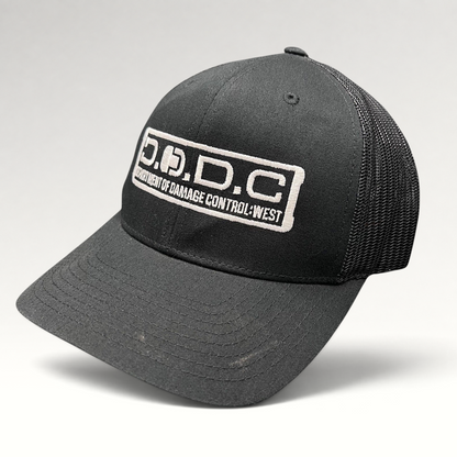 Raree Finds black Marvel Damage Control D.O.D.C. West trucker hat with mesh back and adjustable snapback closure.