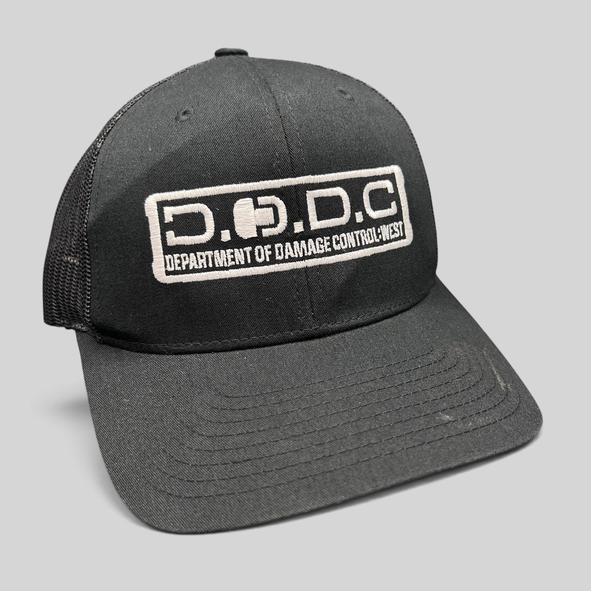 Raree Finds black Marvel Damage Control trucker hat with D.O.D.C. West patch and adjustable snapback closure