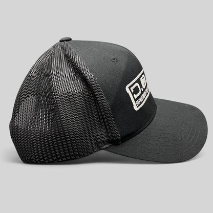 Raree Finds Marvel Damage Control black trucker hat with mesh back and D.O.D.C. West patch, side profile view.