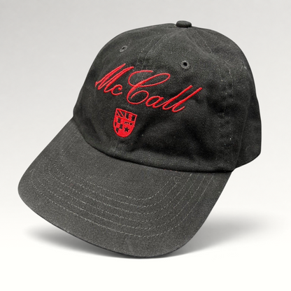 Raree Finds McCall Motor Works black strapback hat with red script embroidery and crest on a dark background