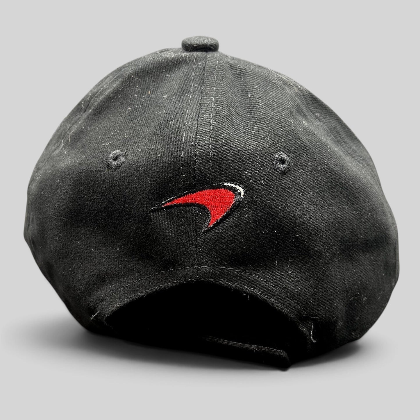 Raree Finds black McLaren cotton strapback hat featuring an embroidered red and white speedmark logo on the back