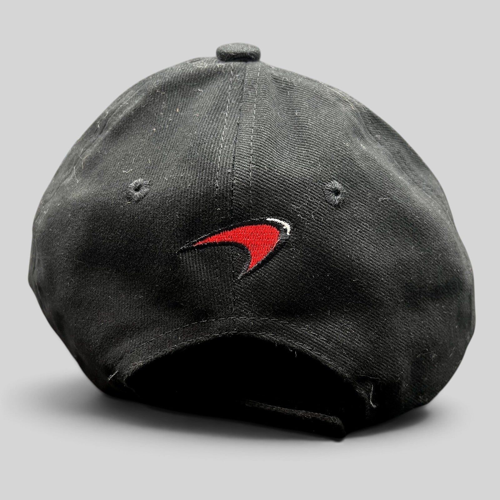 Raree Finds black McLaren cotton strapback hat featuring an embroidered red and white speedmark logo on the back