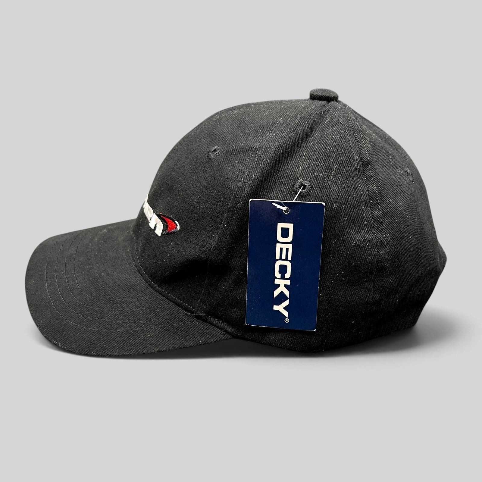 Raree Finds black cotton McLaren logo strapback hat with Decky brand tag, side profile view.