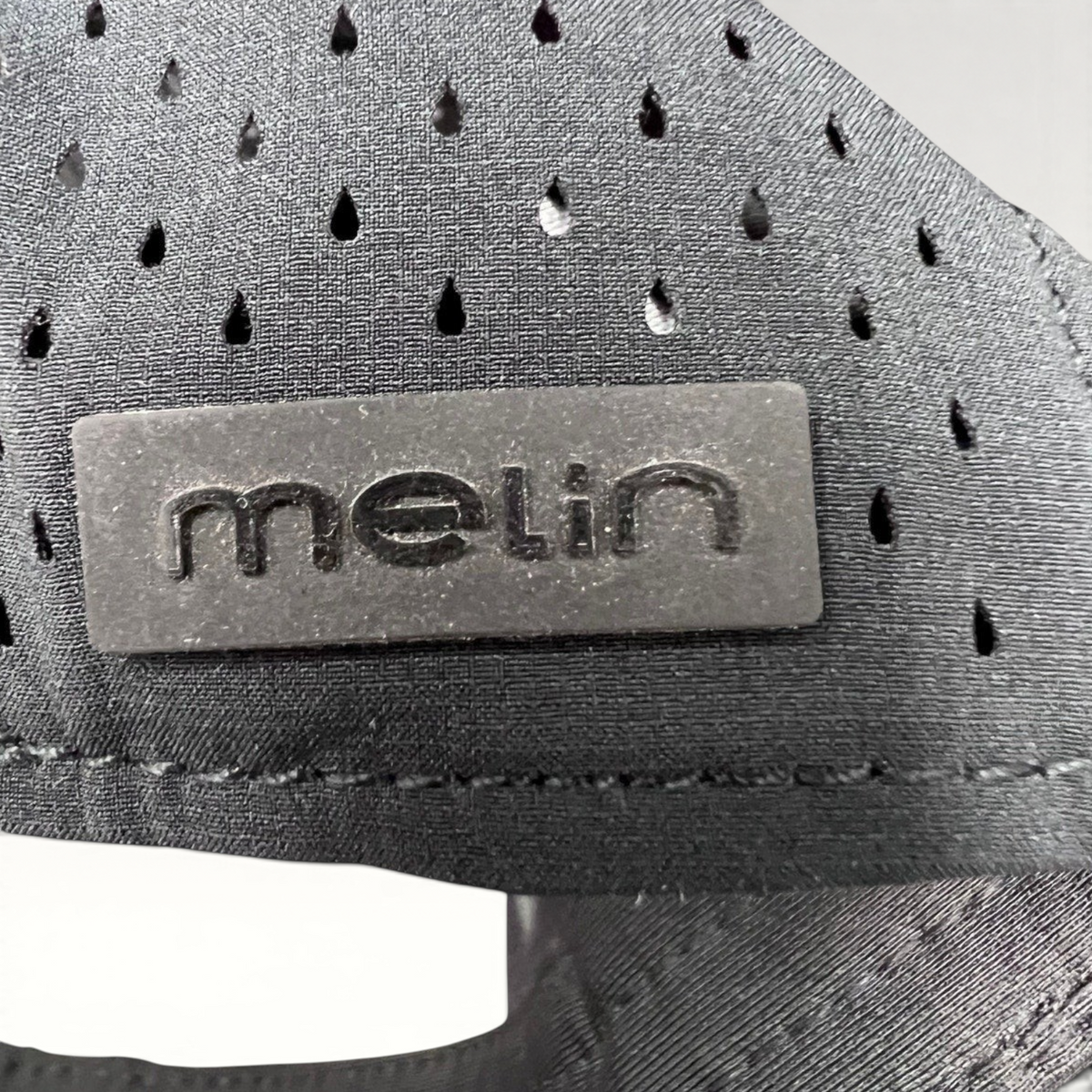 Raree Finds black Melin snapback hat featuring a matte black logo patch and laser-cut ventilation detailing